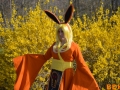 Photo of a Flareon cosplay consisting of an orange robe with yellow fur trim, orange ear headband, and blonde wig.