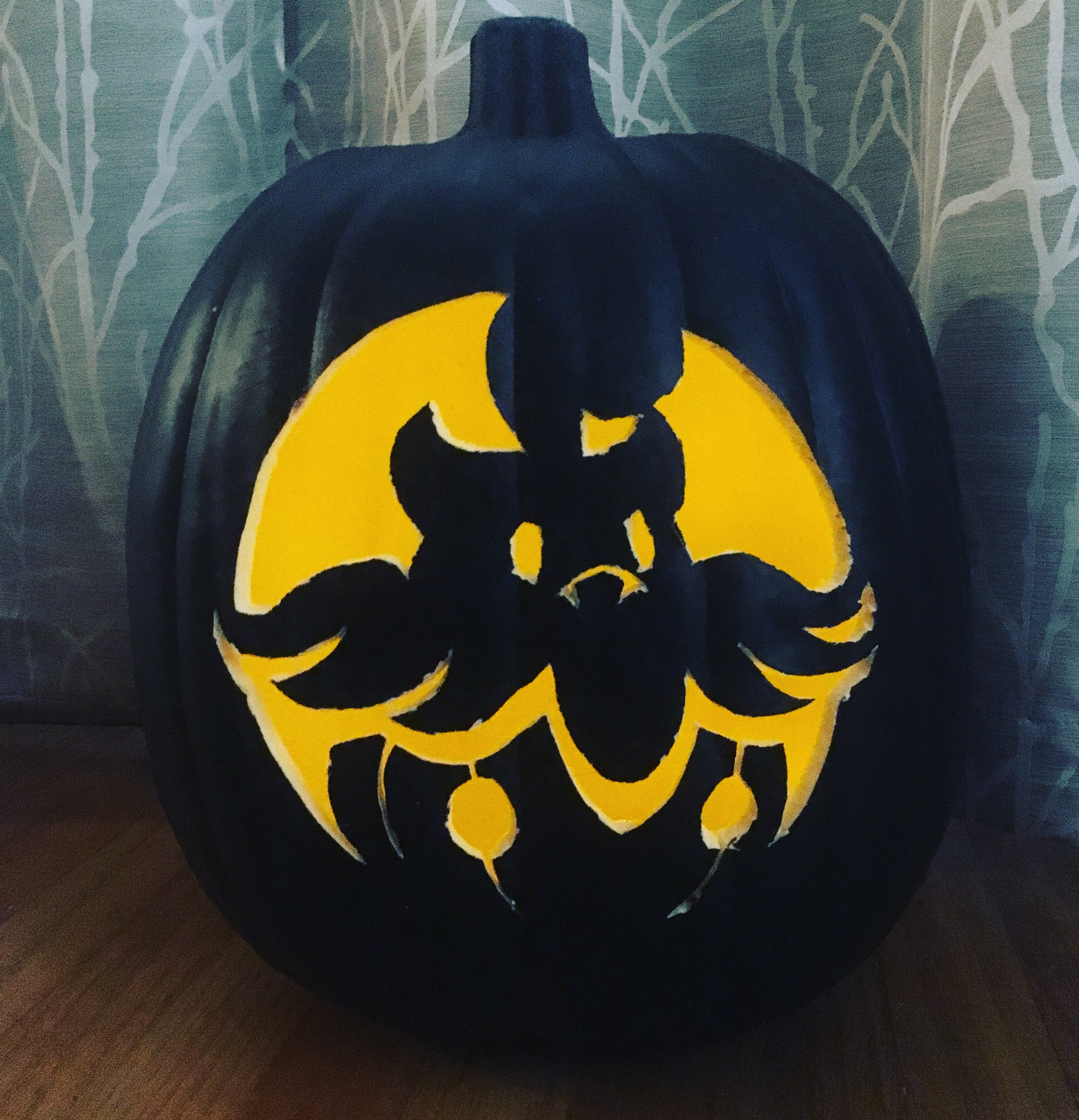 Black foam pumpkin carved with an image of the Pokemon Pumpkaboo and lit from within.