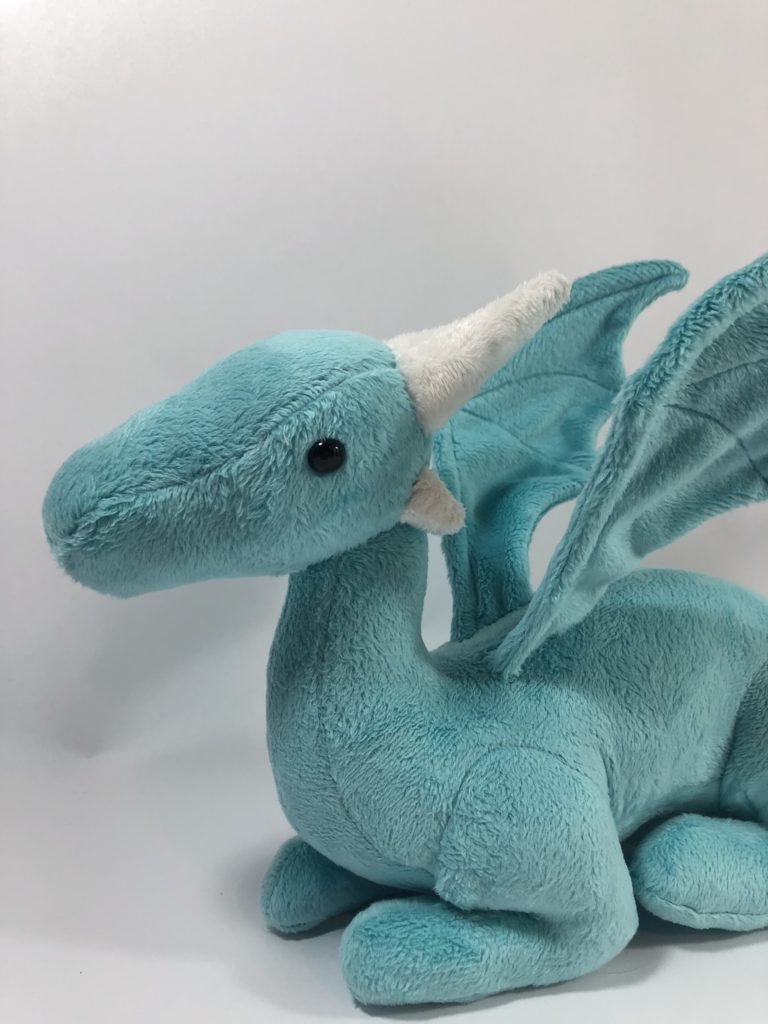 close up of teal dragon plush prototype