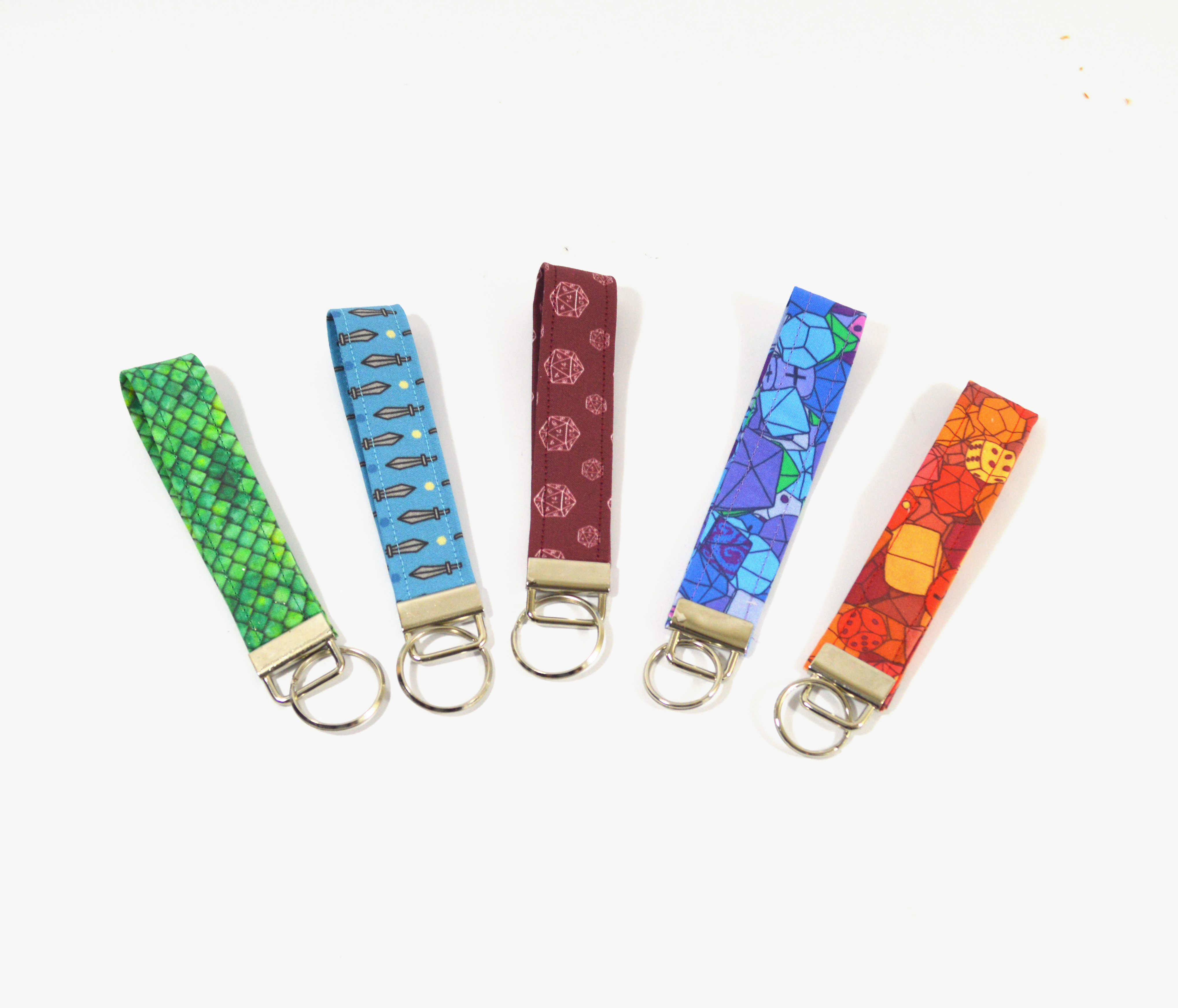 A set of 5 fabric fob keychains, each in a different nerdy color and design.